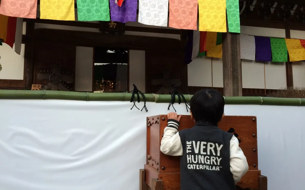 お賽銭箱を覗こうとする子