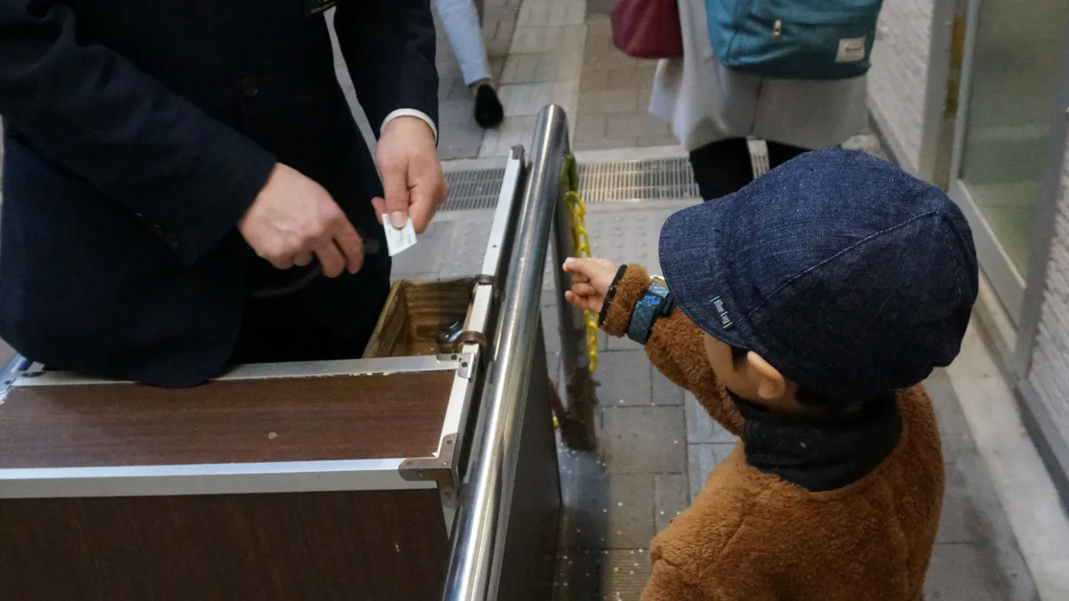 高尾山ケーブルカー乗り場で切符を切る